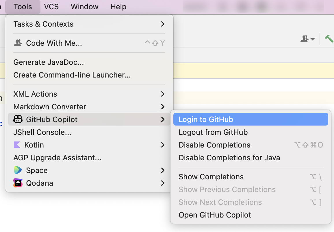 展開された [ツール] メニューと [GitHub Copilot] サブメニューのスクリーンショット。 [GitHub へのログイン] オプションが青色で強調表示されています。
